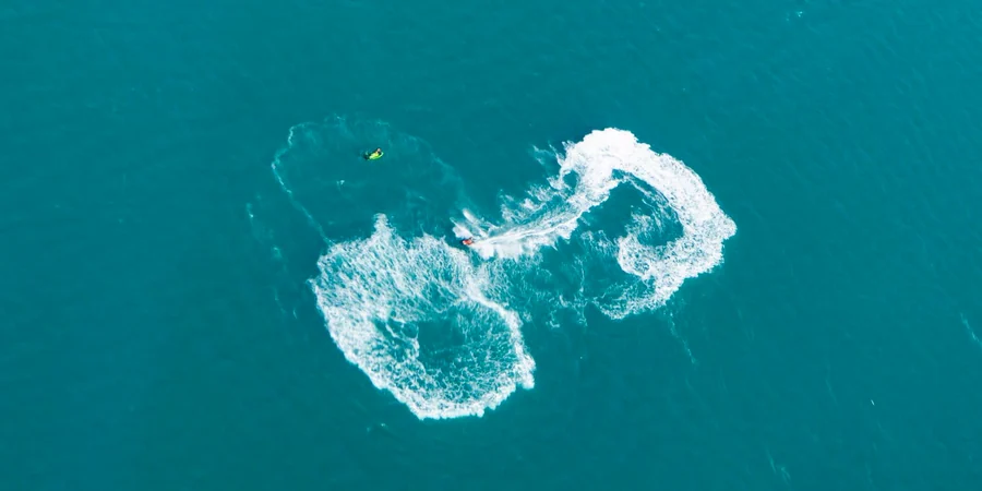 Aerial view of a jet ski trail on the turquoise Gulf near Al Marjan Island, Ras Al Khaimah